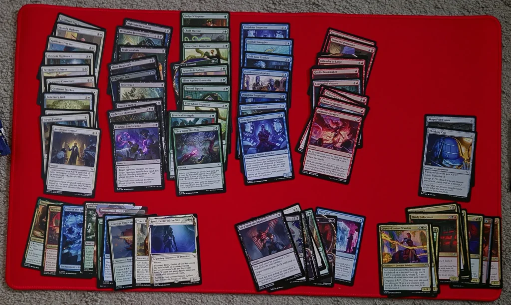 Sealed card pool organized on a playmat at an MTG prerelease - rares, removals, color stacks. 